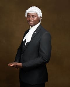 Elegant portrait of an African lawyer wearing traditional legal attire including a wig and gown.